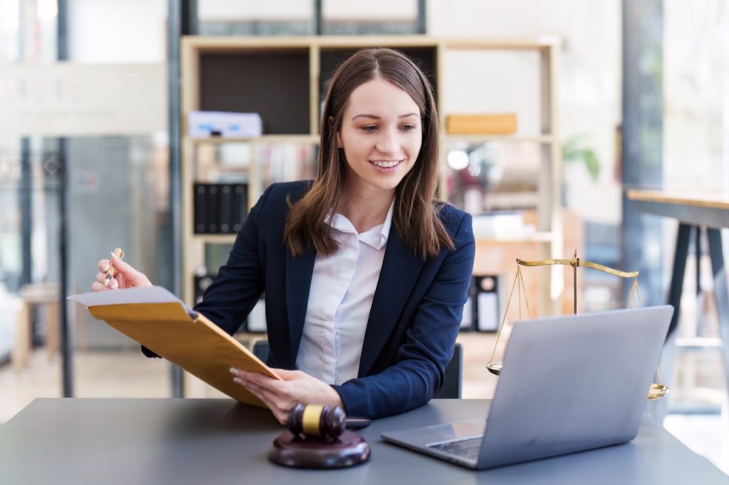 A concentrated law clerk browsing through legal researching software, gathering legal information for a case.